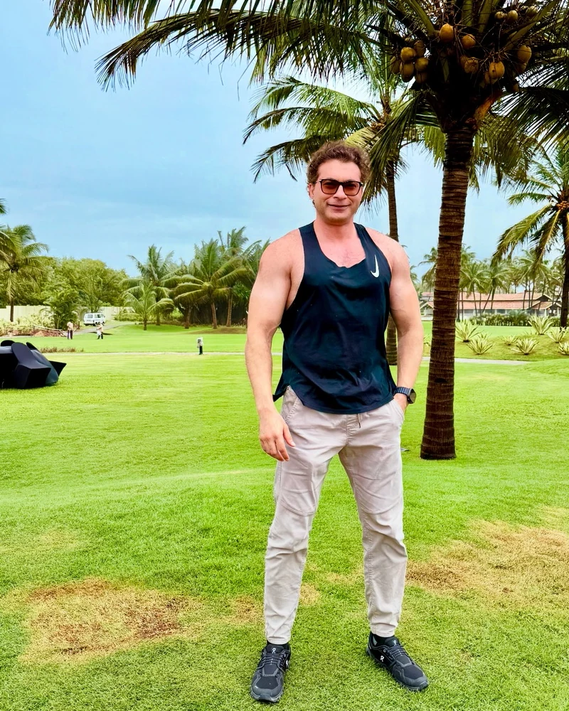 Farhan Ahmad standing outdoors beside palm trees.