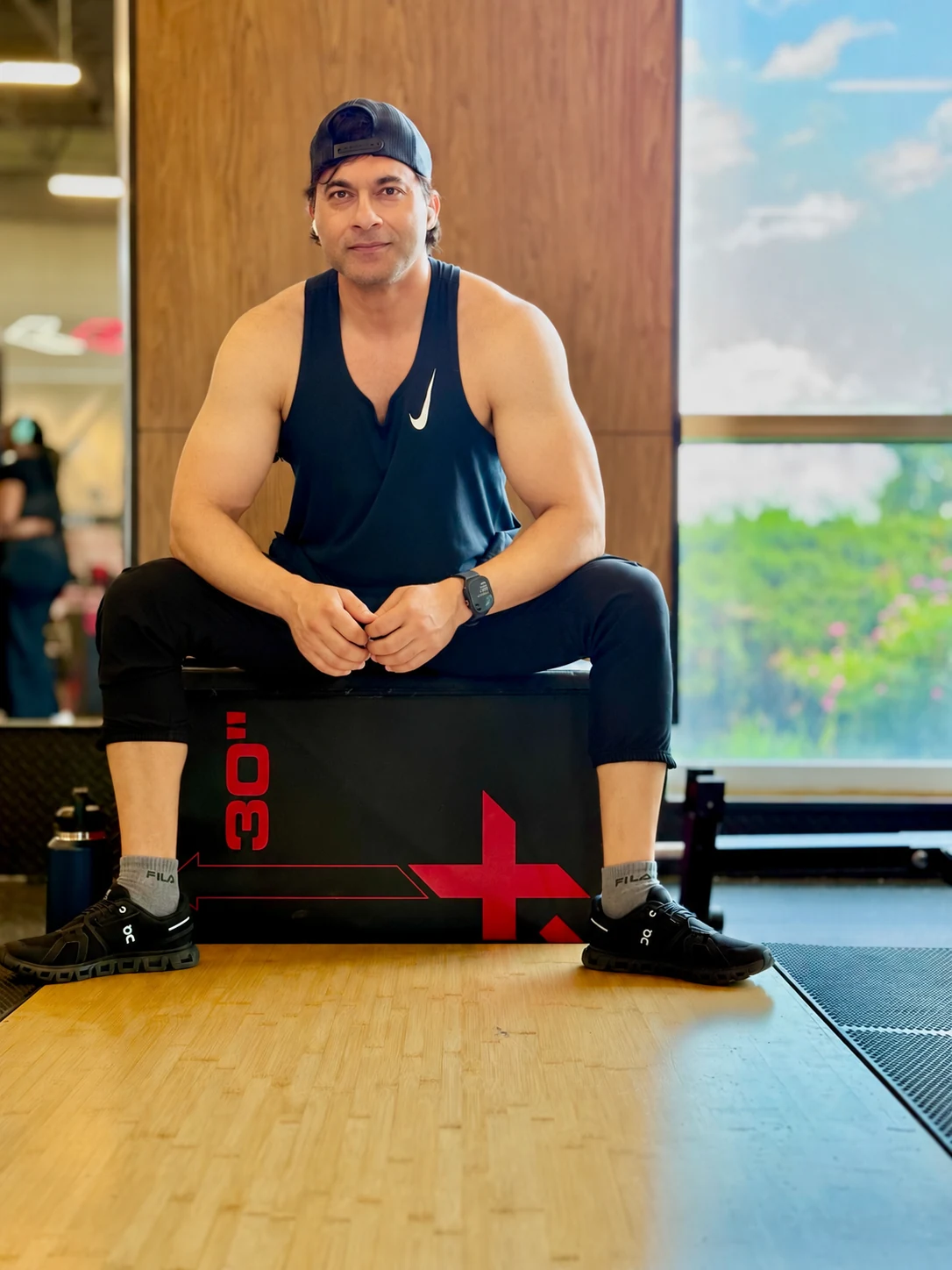Farhan Ahmad seated on a training box in a gym.